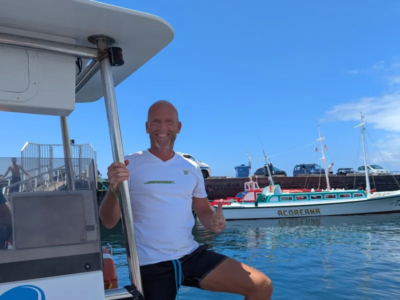 Dirk steht mit Daumen hoch auf dem Boot im Hafen von Lajes