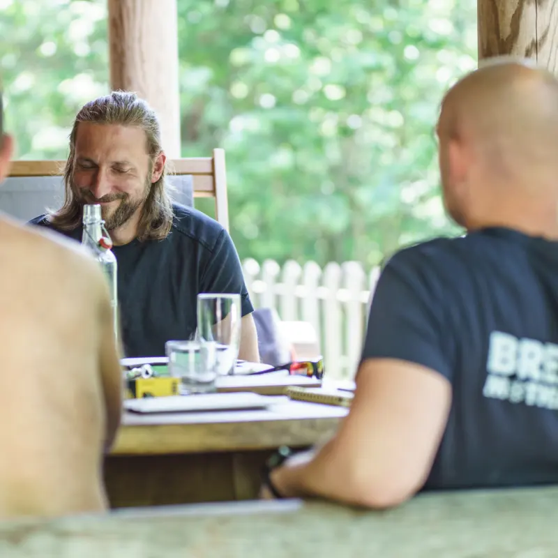 Gesprächsrunde am großen Holztisch auf der Terrasse